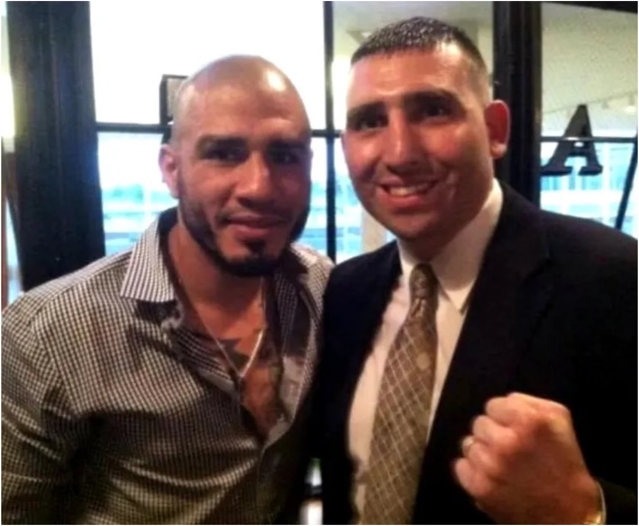 Two men posing together and smiling